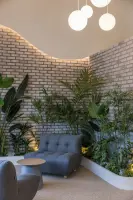 곡선 조명과 초록 정원이 감싸는 아늑한 카페 코너